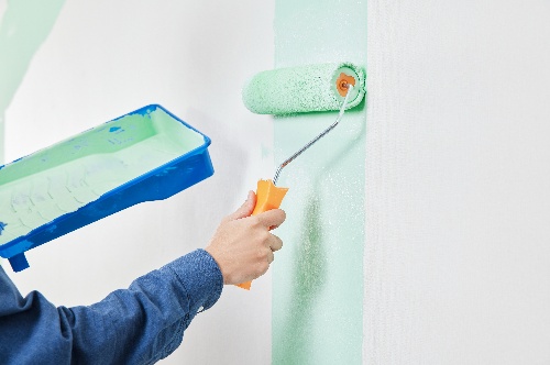 摄图网_501893369_手拿涂料滚筒粉刷墙面手部特写(企业商用)_副本